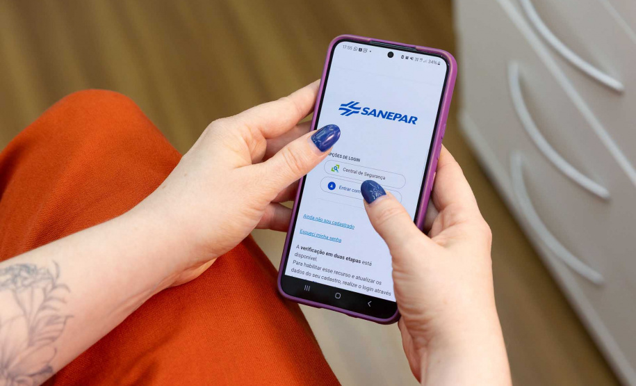 Usuário com celular acessando aplicativo da Sanepar