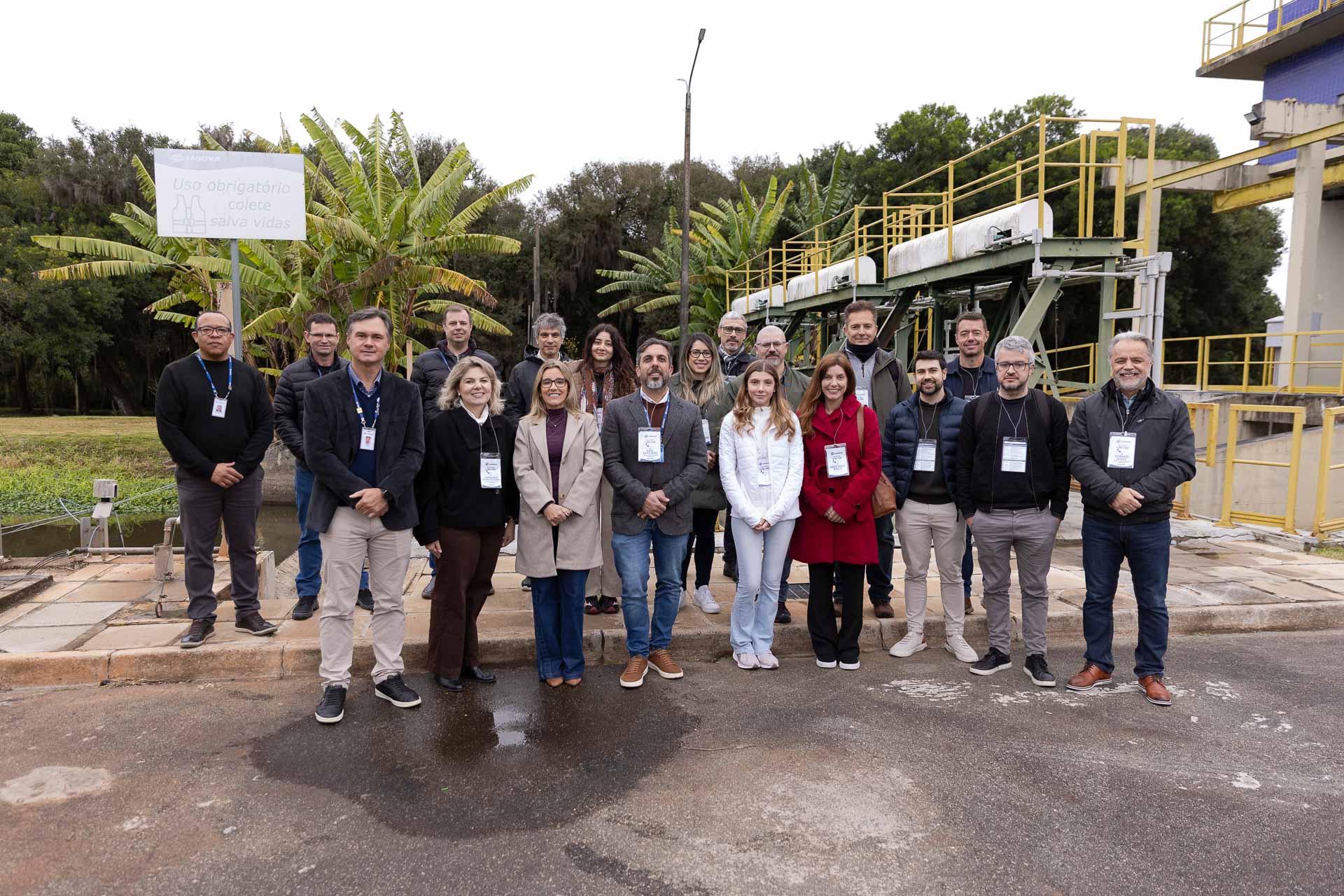 Integrantes da comitiva da Justiça Federal posam juntos para foto oficial em frente às estruturas externas e tanques de tratamento da Sanepar