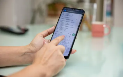Mãos segurando celular com whatsapp da Sanepar