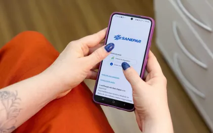 Usuário com celular acessando aplicativo da Sanepar