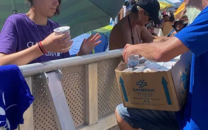 Agente da Sanepar distribui água para veranista