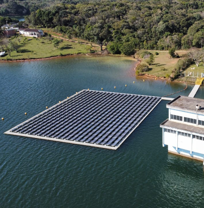lago com um retângulo de placas de captação de energia solar flutuando sobre ele
