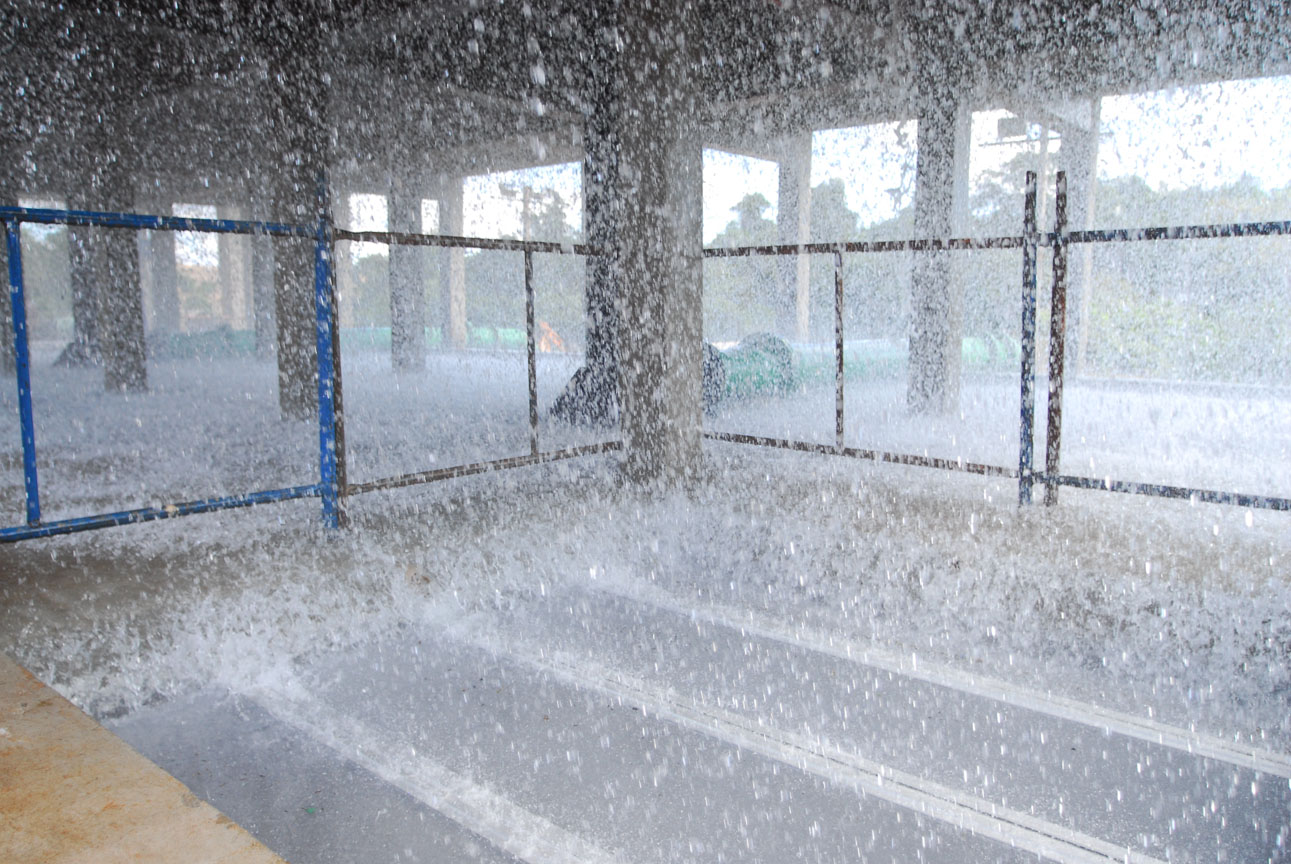 Água jorrando e espirrando com intensidade dentro de estrutura de concreto com grade de proteção durante etapa de aeração.