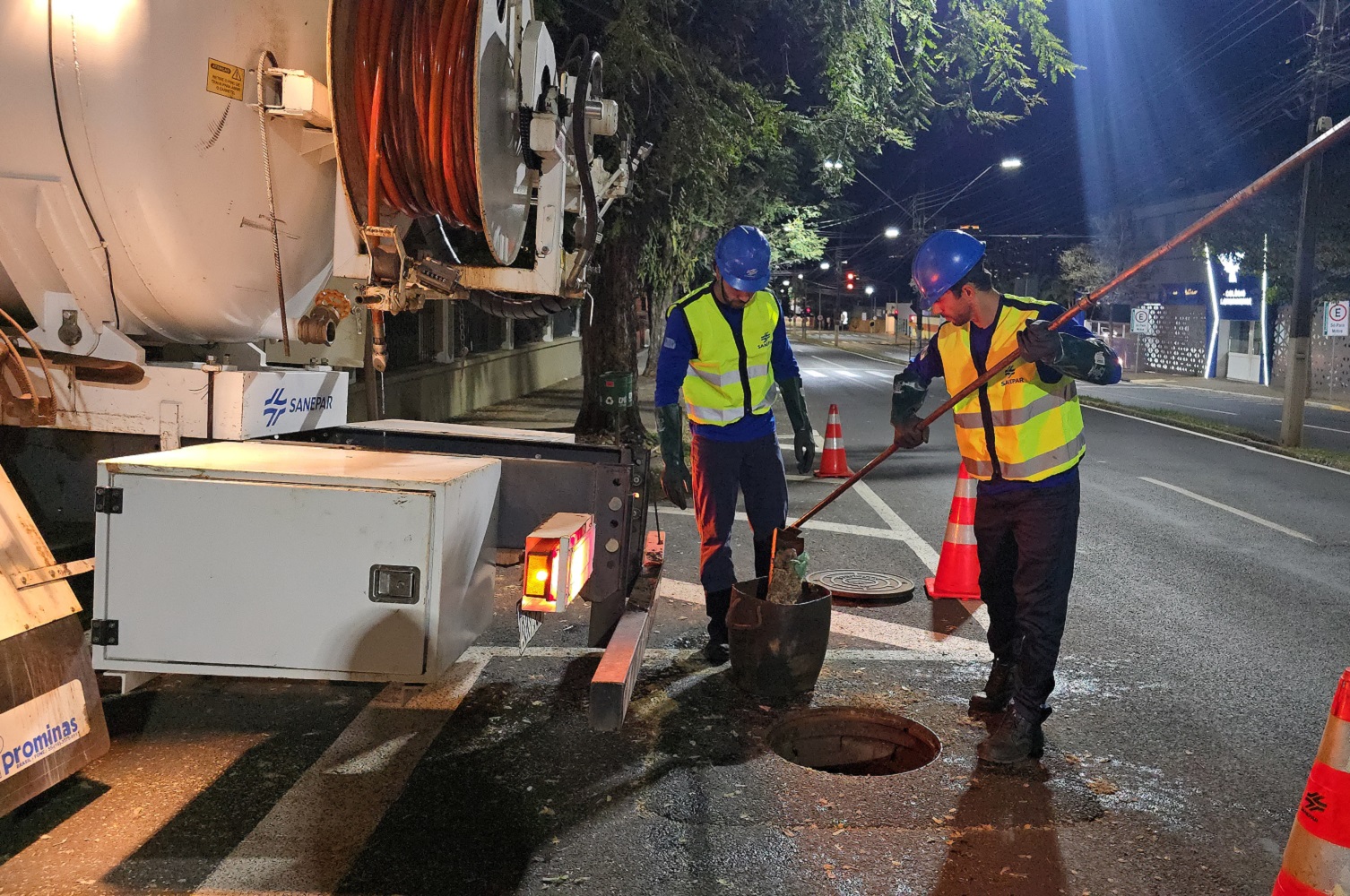 trabalhadores uniformizados usam caminhão de hidrojateamento para fazer manutenção na rede de esgoto