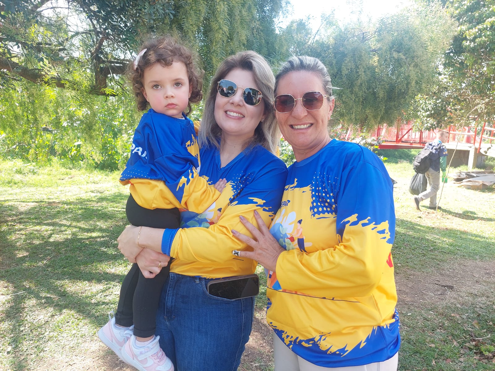 As voluntárias Sabrina Ricetto Karas e Maria Clara (no colo), com a coordenadora Lucilene Costa (Thays Poletto/Sanepar)