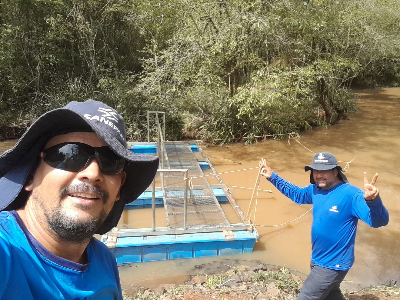Empregados Alexsandro e Plinio junto da ecobarreira