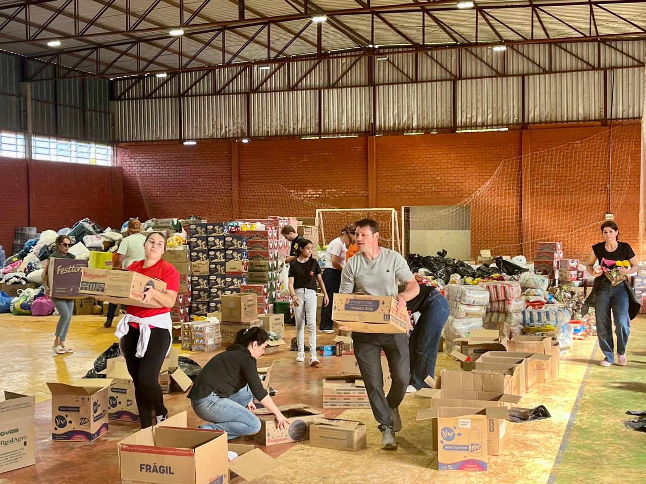 CAIXAS COM COPOS DE AGUA ENVASADOS SAO DESCARREGADOS DE CAMINHÃO