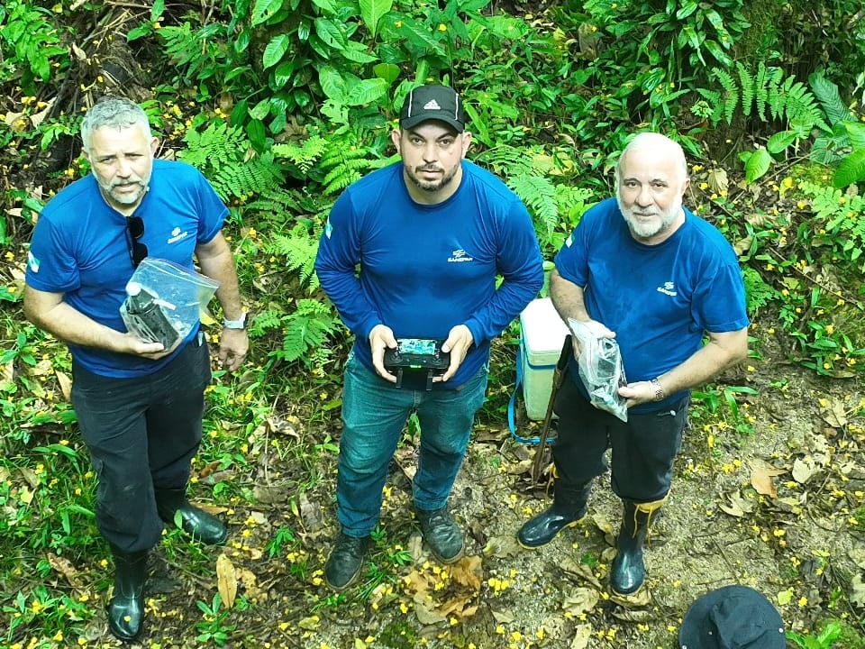 homens segurando equipamentos na mata