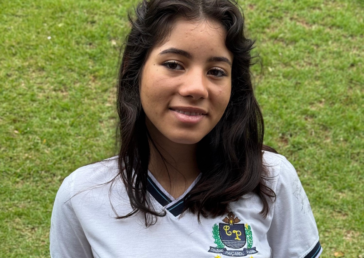 jovem posa com sorriso e uniforme da escola para reportagem