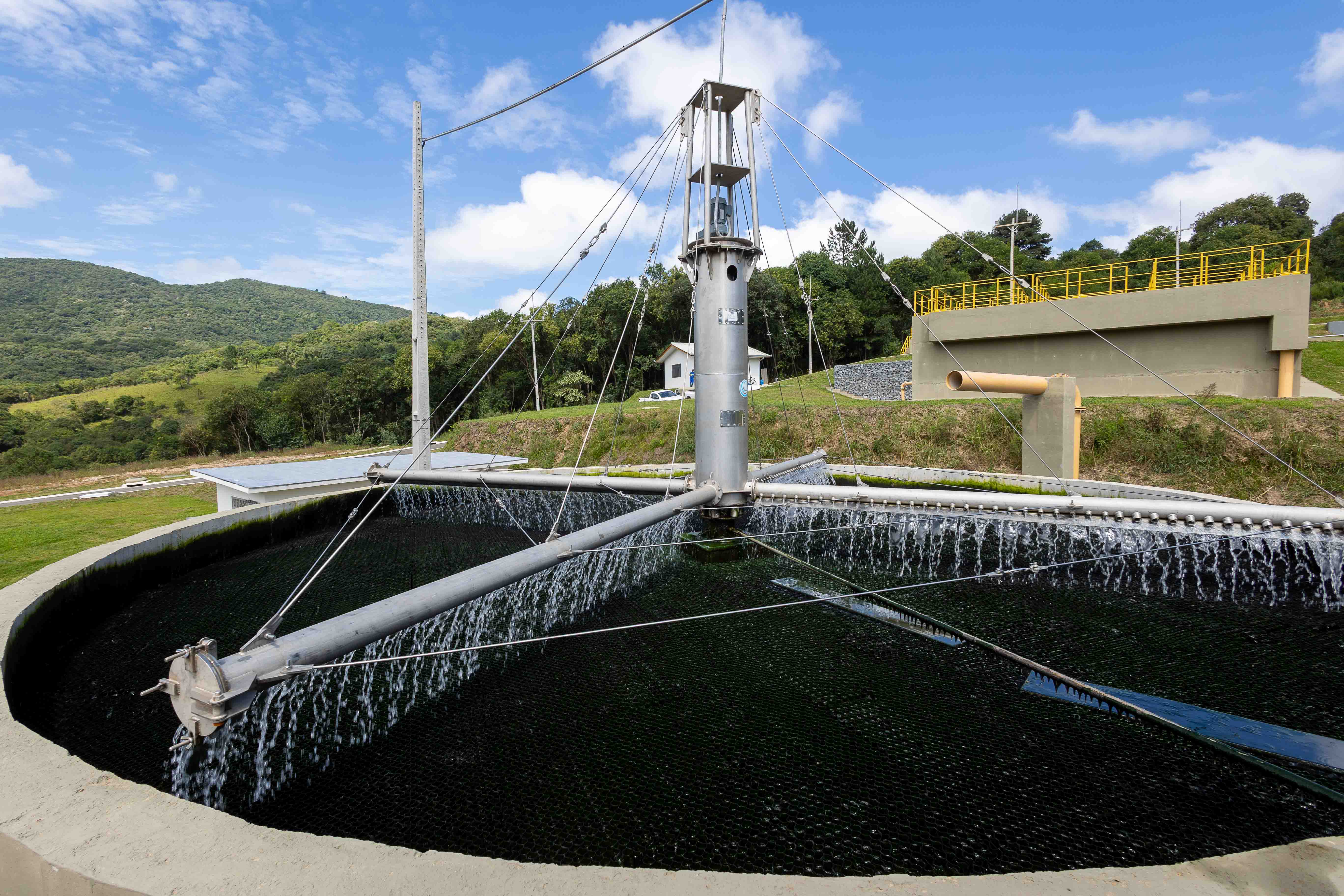 Filtro biológico circular em operação na Estação de Tratamento de Esgoto de Rio Branco do Sul, com braço mecânico distribuindo água sobre a base de filtragem