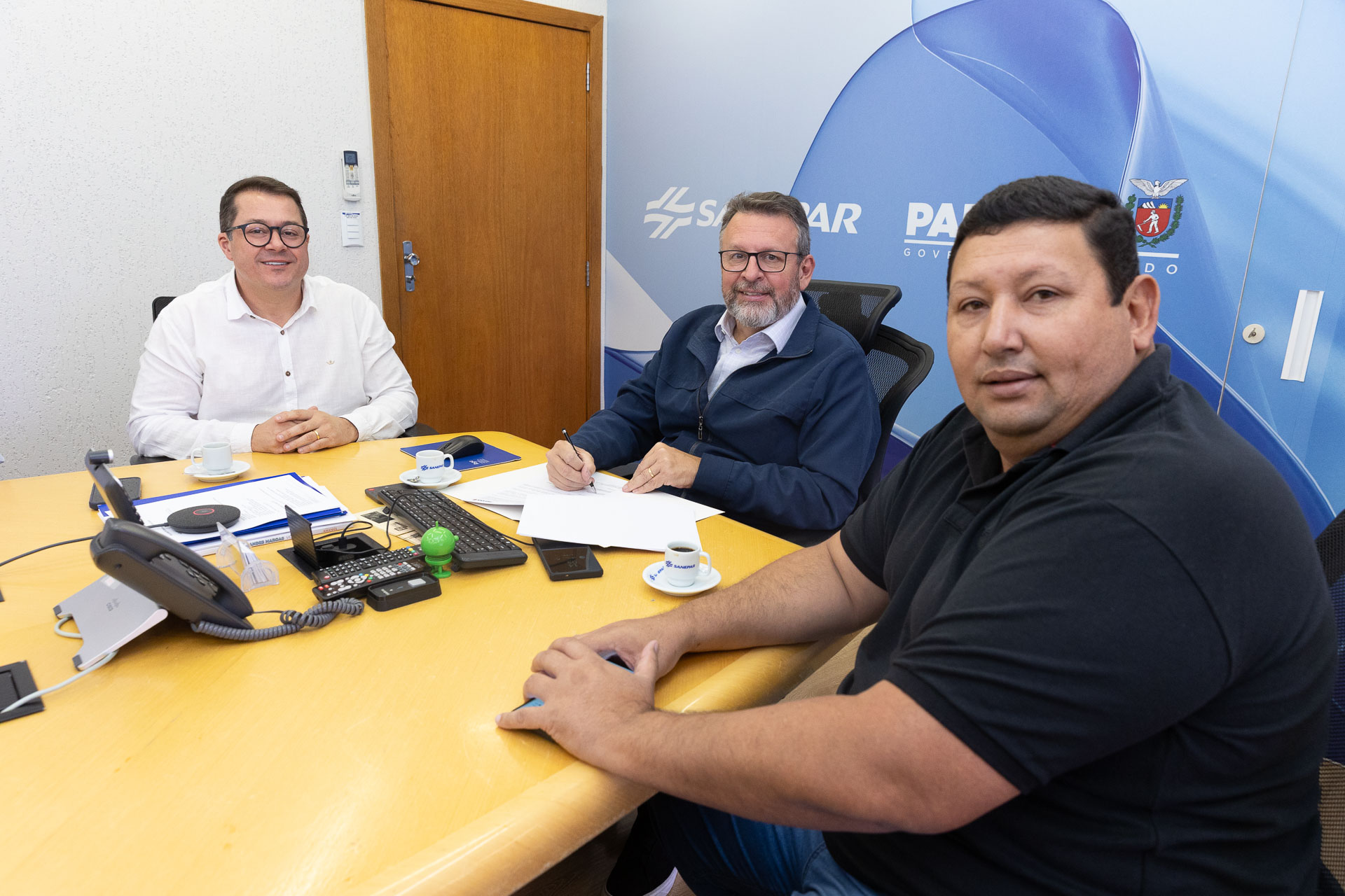 O diretor-presidente da Sanepar, Wilson Bley, assina a nova parceria para abastecer comunidades rurais na Lapa. O prefeito da cidade, Diego Ribas, e o vereador Mário da Farmácia, participaram da reunião que formalizou a parceria.