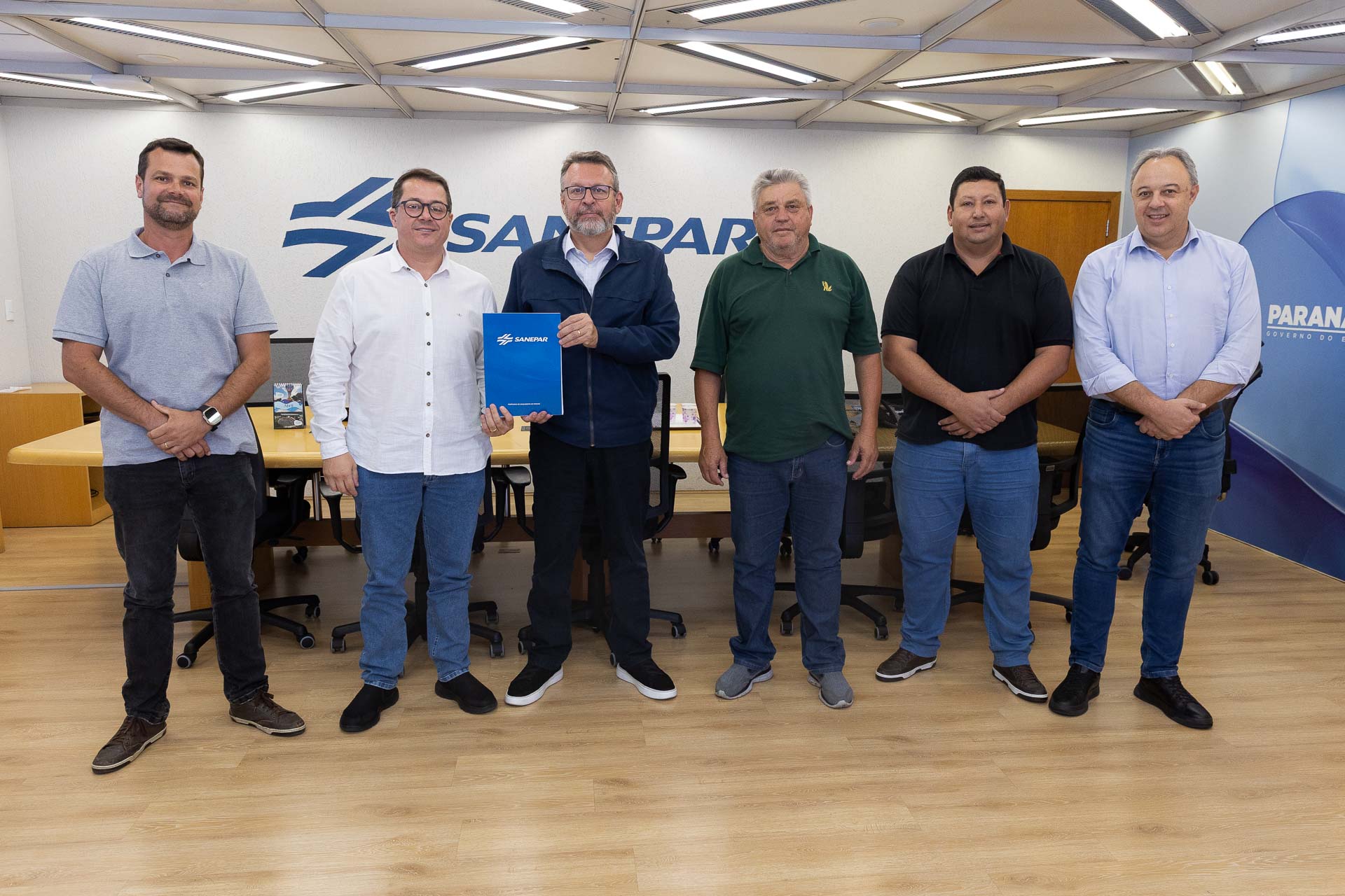 O diretor-presidente da Sanepar, Wilson Bley, e o prefeito da Lapa, Diego Ribas, seguram o documento que prevê obras para ampliar o abastecimento de água em comunidades rurais da cidade.