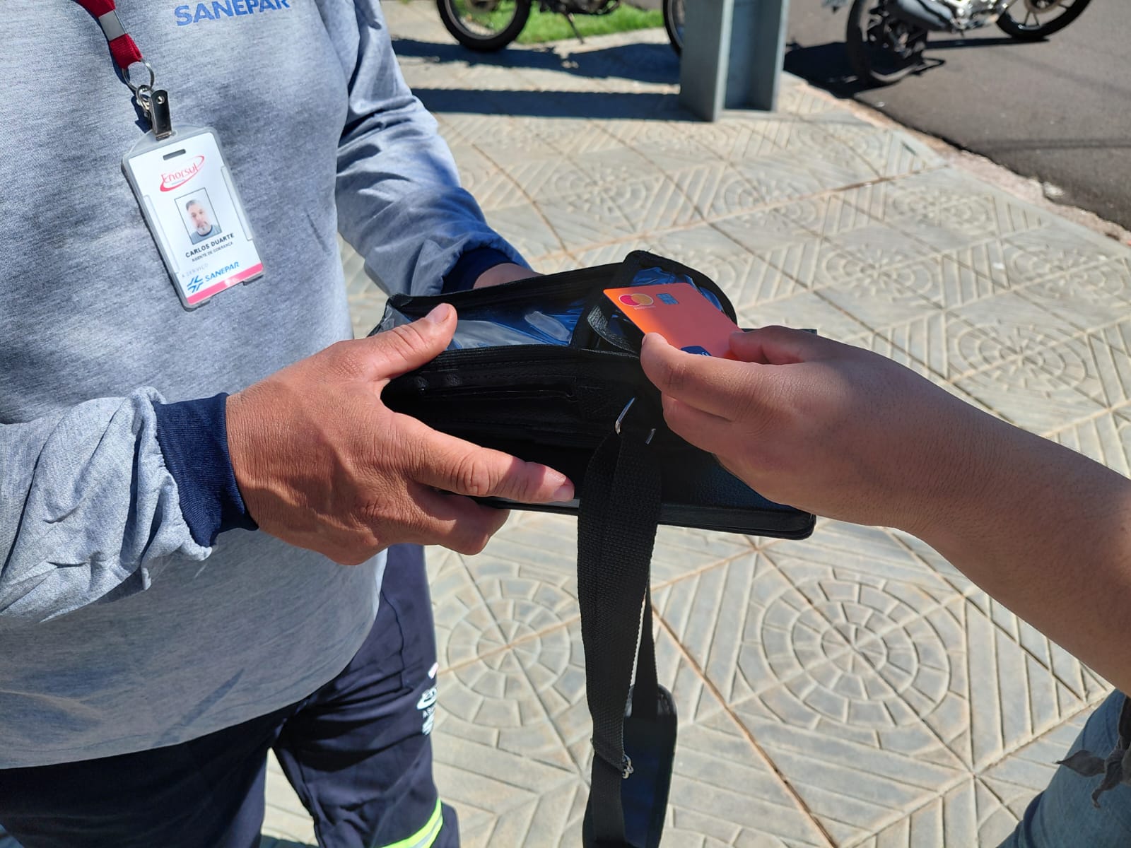 Agente de campo da Sanepar recebe o pagamento de débitos vencidos 