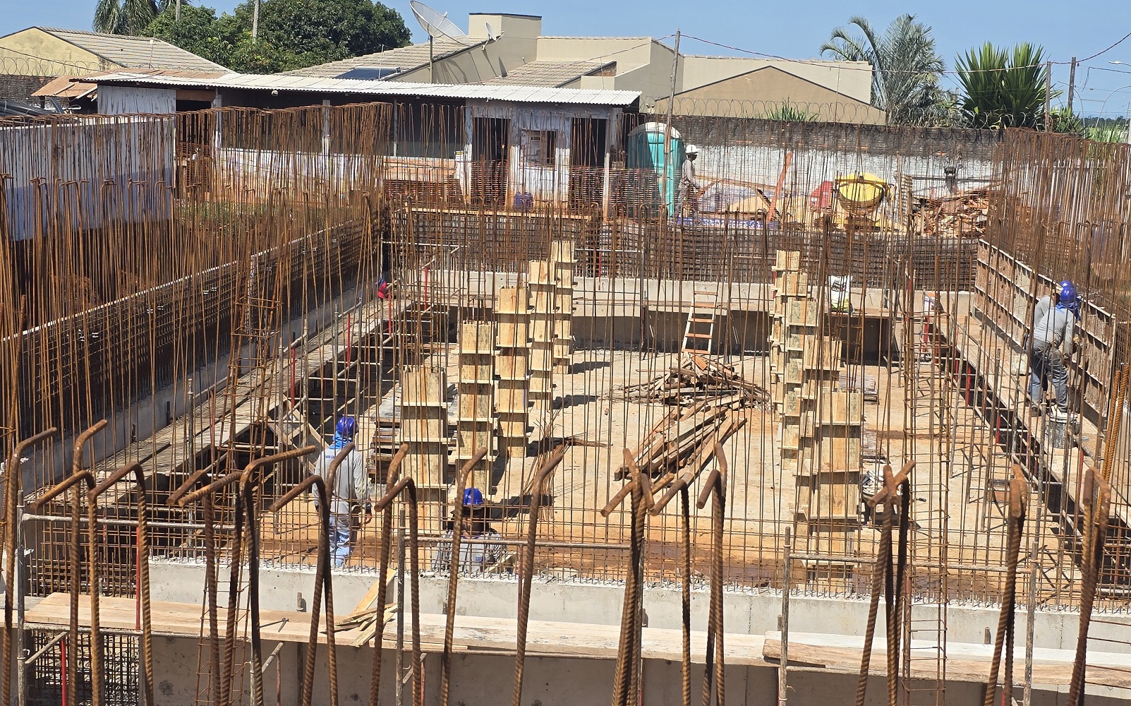 trabalhadores trabalham na construção de um reservatório em concreto. ferragens bem aparentes