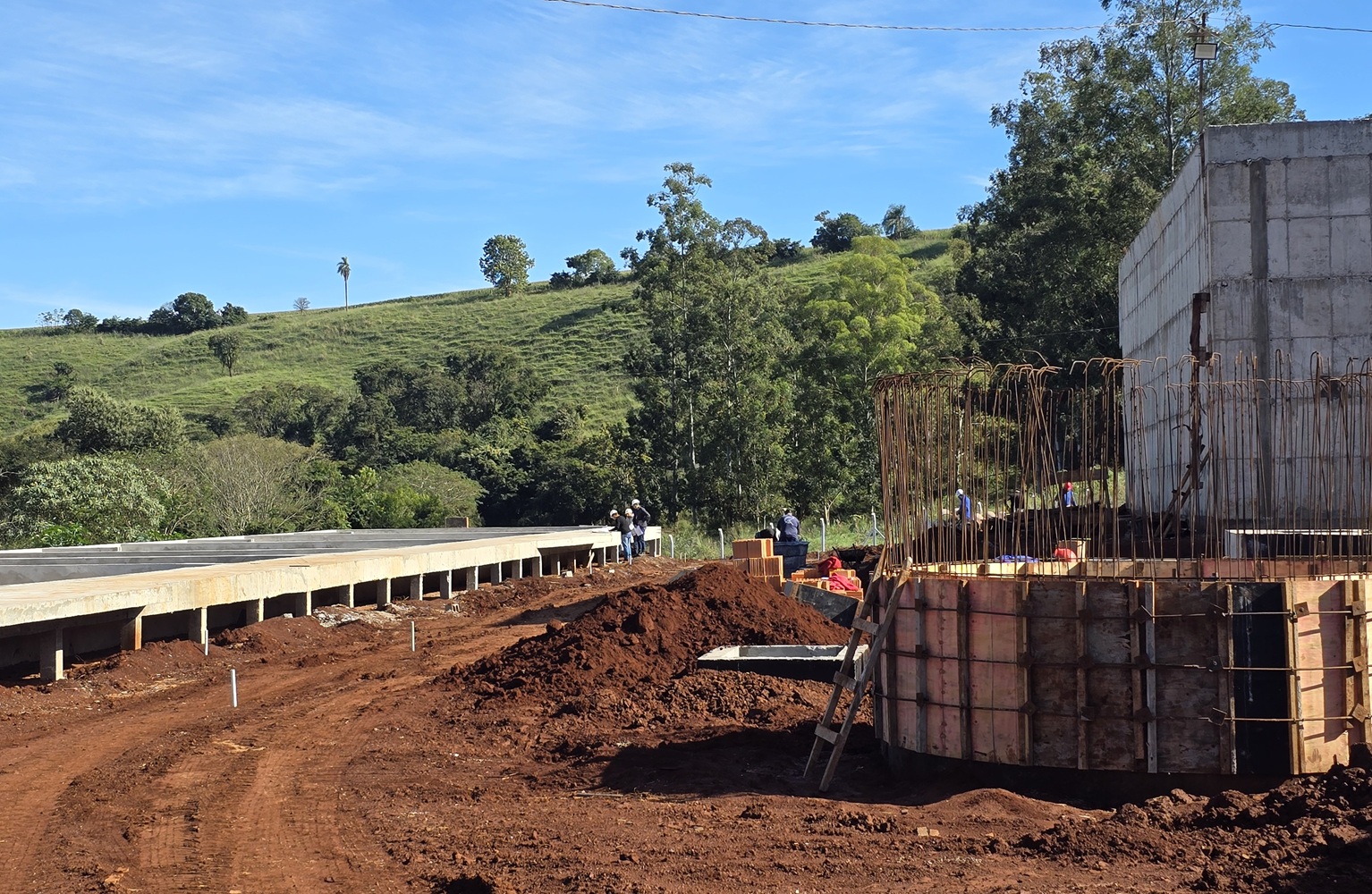 estruturas de concreto em obra de estação de esgoto. ao fundo trabalhador da construção