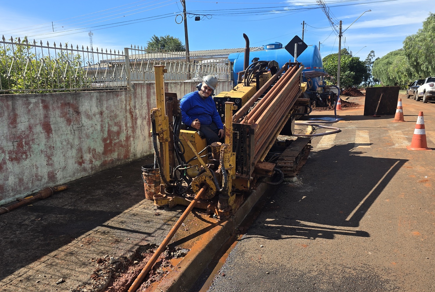 maquina fazendo cravação de tubos na calçada, enterrando, diretamente no subsolo