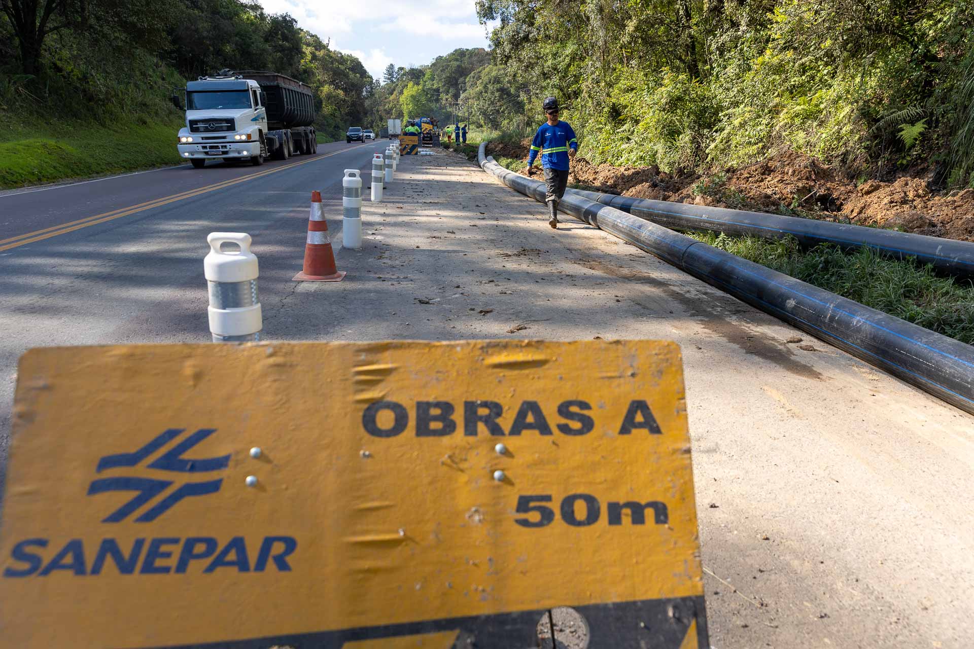 Placa alertando sobre obra ocorrendo perto da estrada
