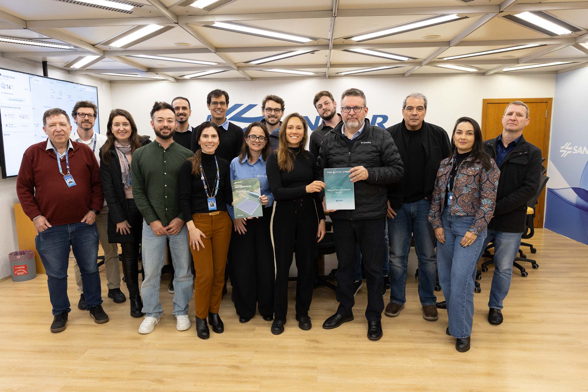 Na imagem, empregados da Sanepar e representantes do consórcio contratado para realizar os estudos e análises que resultaram no Plano de Descarbonização entregam uma versão impressa do documento ao diretor-presidente da Sanepar, Wilson Bley.
