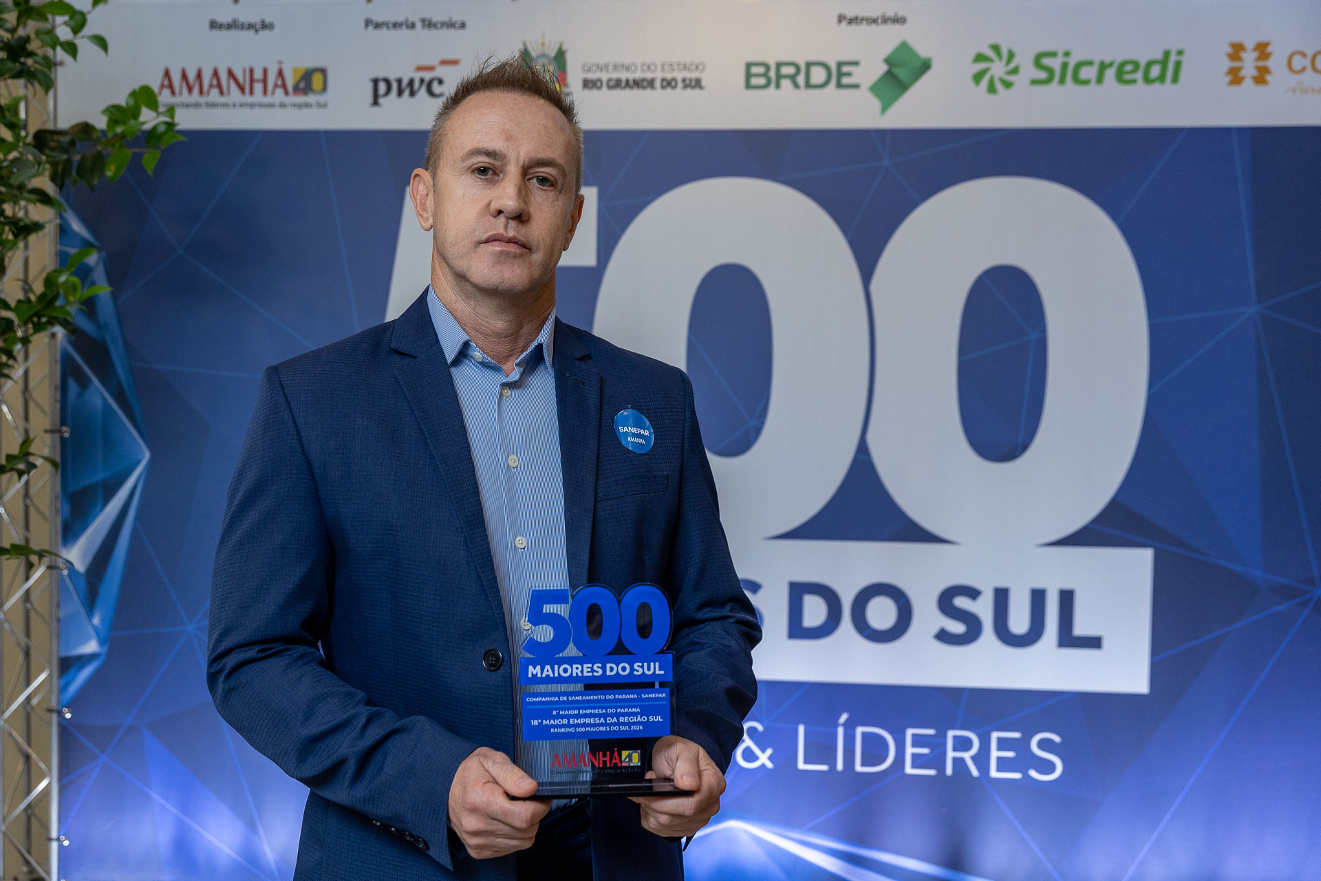 O especialista em Inovação da Sanepar, Charles Carneiro, exibe o troféu de 8ª maior empresa do Paraná.