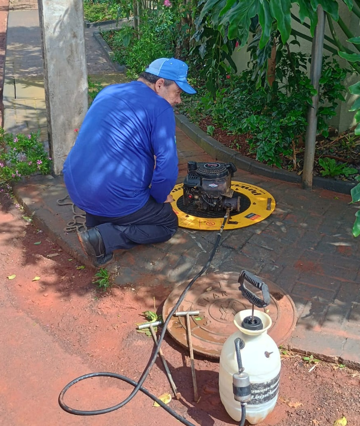 empregado manuseando máquina que faz o teste de fumaça na rede de esgoto