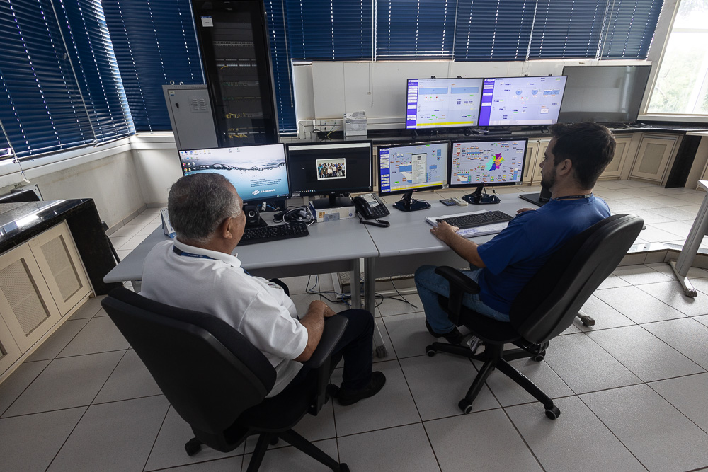 tecnicos no centro de controle operacional observando as telas dos computadores