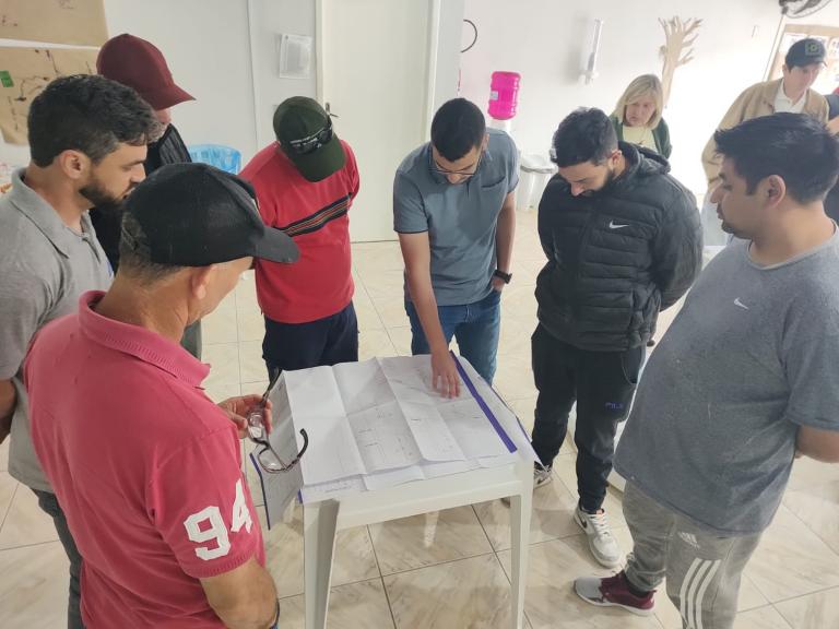 Grupo de pessoas analisando projeto em papel