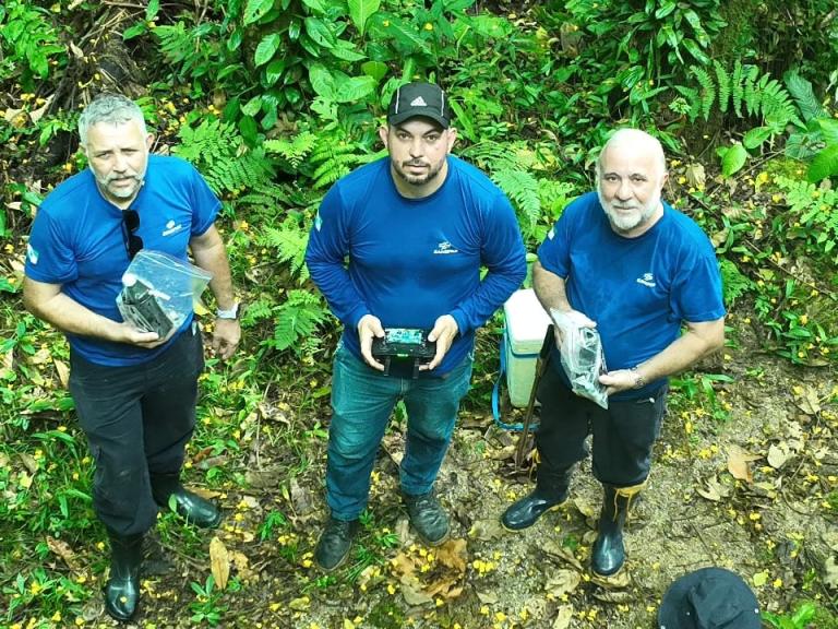 homens segurando equipamentos na mata