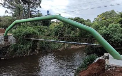 Tubulação de água bruta instalada sobre um rio.