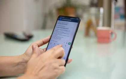 Um celular exibe o perfil Atendimento Sanepar no aplicativo WhatsApp.