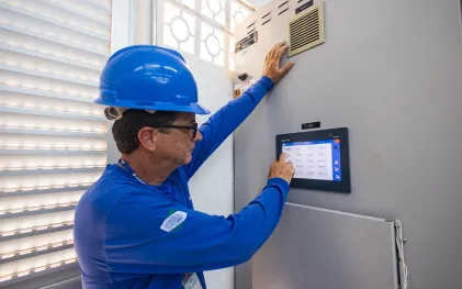 trabalhador acessa painel de comando de automação em estação de tratamento de esgoto