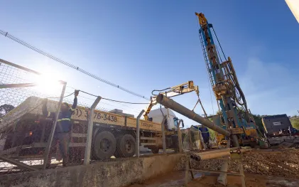 Equipes e máquinas trabalhando em perfuração de poço
