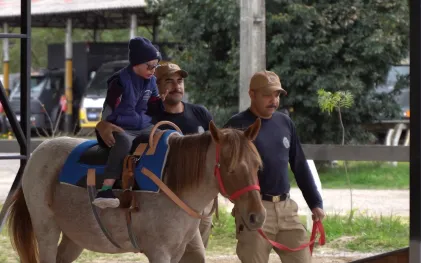 Imagem de Luis Rafael participando da equoterapia