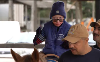 Imagem de Luis Rafael participando da equoterapia