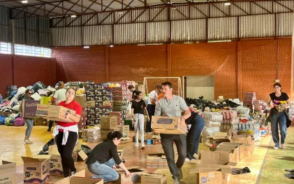 CAIXAS COM COPOS DE AGUA ENVASADOS SAO DESCARREGADOS DE CAMINHÃO