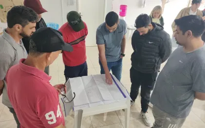 Grupo de pessoas analisando projeto em papel