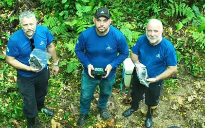homens segurando equipamentos na mata