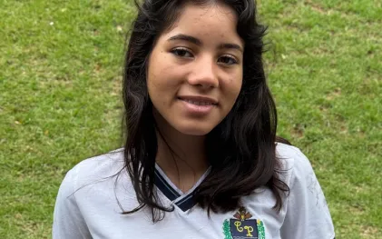 jovem posa com sorriso e uniforme da escola para reportagem