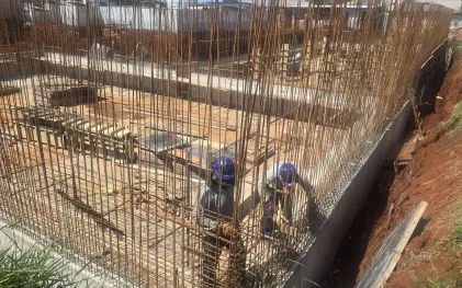 trabalhadores trabalham na construção de um reservatório em concreto. ferragens bem aparentes