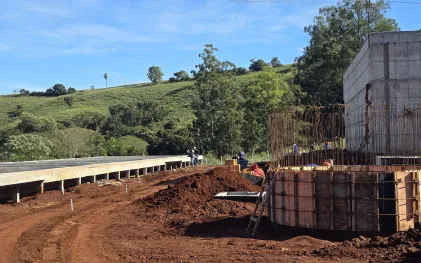 estruturas de concreto em obra de estação de esgoto. ao fundo trabalhador da construção