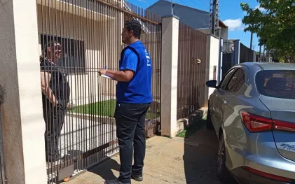 técnicos com uniformes da cor azul abordam clientes no portão de suas casas