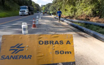 Placa alertando sobre obra ocorrendo perto da estrada