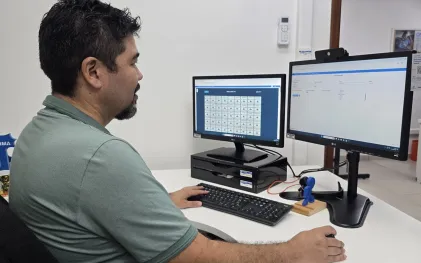gestor visualiza telas do sistema de monitoramento operacional no computador de mesa