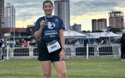 Participante da Corrida Sanepar em Toledo mostra medalha