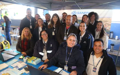 Equipe da Sanepar posa para foto. Parte dos empregados está sentada e outra parte alinhada ao fundo. Todos, homens e mulheres, estão uniformizados.